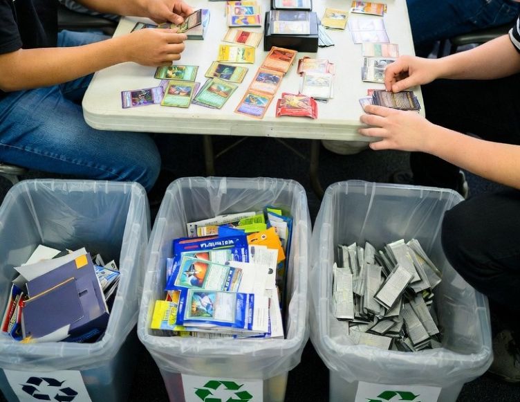 Hobbyists sorting trading cards and packaging materials for reuse and recycling
